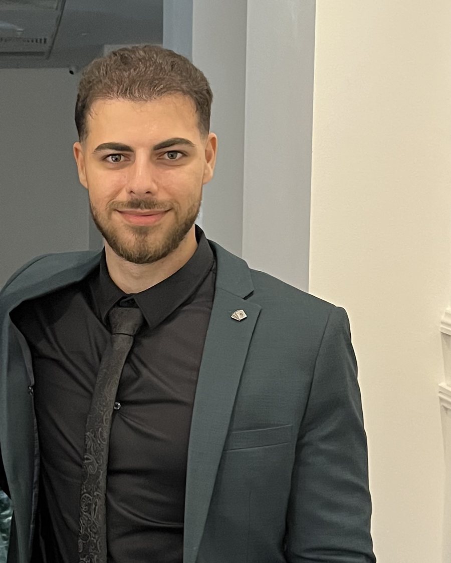 Baz Goran, founder of Step 2 Scale, in a dark green suit
